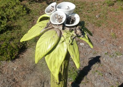 Aliensus Sexuada Greengodda   Shaw Installation Description: As described in “The Field Guide to Alien Botanicals,” Sexuada is the only aliensus to reproduce through pollination.  Their structural nodes contain genetic information that allow them to regenerate  when cut and also help support their heavy structure.  Sexuada produces chorofil. Width: 15” x Height: 68” Stoneware and Porcelain